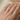 Gold band with a smooth texture on a finger with a blurred background