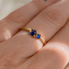 Load image into Gallery viewer, model-wearing-14k-gold-ring-with-two-dark-blue-sapphires