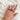 Hand wearing a stack of mixed metal diamond rings in sterling silver and 14k gold with skull crown ring