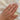person-with-hand-tattoos-wearing-thick-gold-band-with-two-prong-set-diamonds