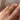 A vintage 22k yellow gold band with olive branch imagery worn on a person's finger.