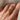 A vintage 22k yellow gold band with olive branch imagery worn on a person's finger.