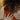 curly-haired-woman-wearing-orange-dress-wearing-gold-rings