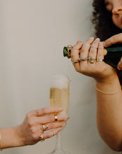 Load image into Gallery viewer, woman-pouring-overflowing-champage-into-a-flute-held-by-hand-wearing-lots-of-rings