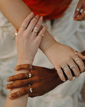 Load image into Gallery viewer, three-people-holding-each-others-hands-wearing-gold-and-silver-bands-and-diamond-rings