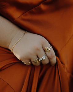curvy-woman-wearing-gold-and-silver-rings-and-rope-chain-bracelet