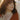 curly-haired-woman-in-rust-dress-wearing-silver-and-gold-rings