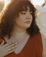 Load image into Gallery viewer, curly-haired-woman-in-rust-dress-wearing-silver-and-gold-rings