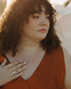 curly-haired-woman-wearing-orange-dress-and-rings