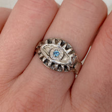Load image into Gallery viewer, close-up of hand wearing a sterling silver ring. Eyeball ring with light blue sapphire.