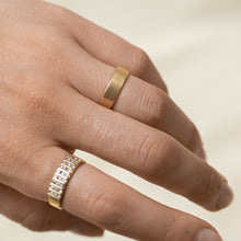 Load image into Gallery viewer, Gold band with a smooth texture on a person&#39;s finger against a neutral background