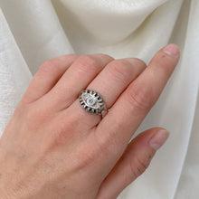 Load image into Gallery viewer, hand with sterling silver ring on middle finger in front of white backdrop. Eyeball ring with pale blue sapphire.