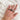 Hand wearing a stack of mixed metal diamond rings in sterling silver and 14k gold with skull crown ring
