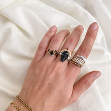 Load image into Gallery viewer, Hand wearing a stack of mixed metal diamond rings in sterling silver and 14k gold with skull crown ring