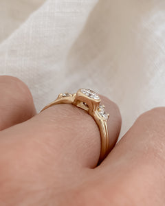 Side view of diamond in a raised setting on a gold ring.
