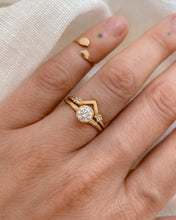 Load image into Gallery viewer, Round, bezel set diamond solitaire gold ring on a hand against a neutral background
