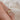 Gold, diamond ring on a finger against a soft background