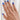 Woman with blue nails wearing diamond solitaire ring