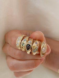 Hand-wearing-a-handful-of-signet-rings-with-different-gemstone designs