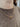 Gold chain necklace worn by a person in a brown sweater