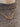 Gold chain necklace with interlocking rings worn by a person on a brown textured background