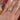 Person wearing toi et moi style engagement ring with one pear shaped diamond and one oval shaped diamond, side by side in melty setting. 