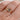 Gold ring with a salt and pepper diamond on a person's finger