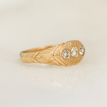 Load image into Gallery viewer, A gold ring with three white diamonds set in a hand-engraved pattern on the band.