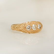 Load image into Gallery viewer, A gold ring with three white diamonds set in a hand-engraved pattern on the band.