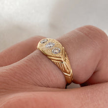 Load image into Gallery viewer, Woman wearing a gold ring with three white diamonds set in a hand-engraved pattern on the band.