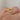 A gold ring with a double headed snake design wrapped around the band, displayed on a person's finger.
