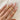 A close-up image of a person's fingers wearing three gold signet rings with the initials 'D', 'T', 'S' on each ring.