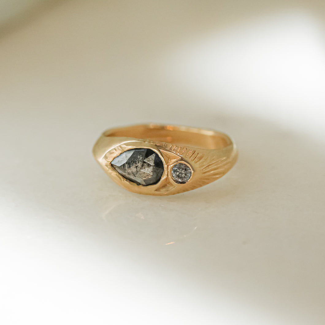 A signet ring with a salt and pepper diamond set in a hand-engraved band of recycled 14k gold, featuring a handcrafted design.