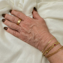 Load image into Gallery viewer, Hand wearing a yellow gold band with a smooth texture