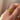 A vintage 22k yellow gold band with olive branch imagery worn on a person's finger.