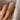 A vintage 22k yellow gold band with olive branch imagery worn on a person's finger.