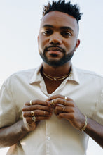 Load image into Gallery viewer, man-leaning-over-camera-wearing-rings-and-necklaces