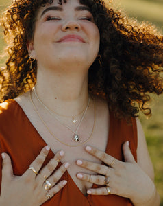 smiling-curly-haired-woman-wearing-handmade-silver-and-gold-jewelry