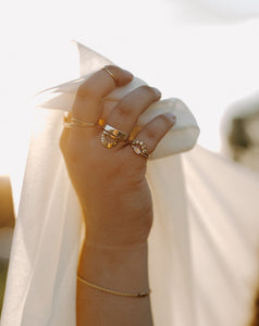 curvy-woman-wearing-gold-wedding-ring set-and-stacking-rings