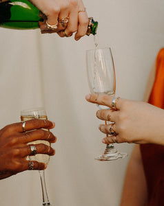 person-wearing-rings-pouring-glasses-of-champagne