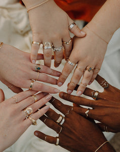 many-hands-in-frame-wearing-gold-and-silver-rings-and-bands
