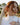 red-headed-woman-wearing-sapphire-diamond-earrings-and-layered-gold-necklaces