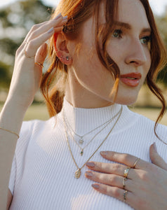 red-head-wearing-layered-gold-and-silver-necklaces-and-earrings