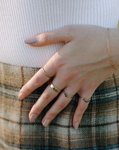 woman-wearing-black-diamond-arched-half-halo-ring-and-gold-bands