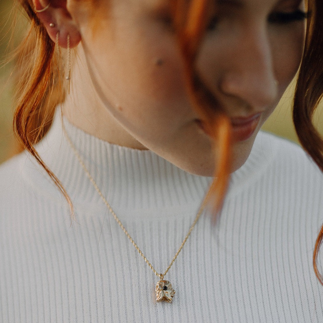 woman-wearing-gold-two-sided-skull-and-face-pendant-with-diamonds-on-a-rope-chain-necklace