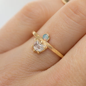 person wearing a rose cut diamond & opal 14k gold engagement ring