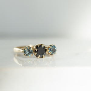 black diamond ring with brilliant cut blue sapphires