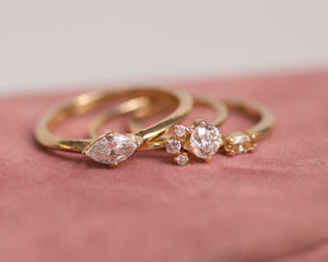 three-diamond-engagement-rings-on-pink-background