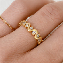 Load image into Gallery viewer, Person wearing infinity ring of wavy 14k gold with diamonds