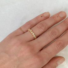 Load image into Gallery viewer, Person wearing infinity ring of wavy 14k gold with diamonds